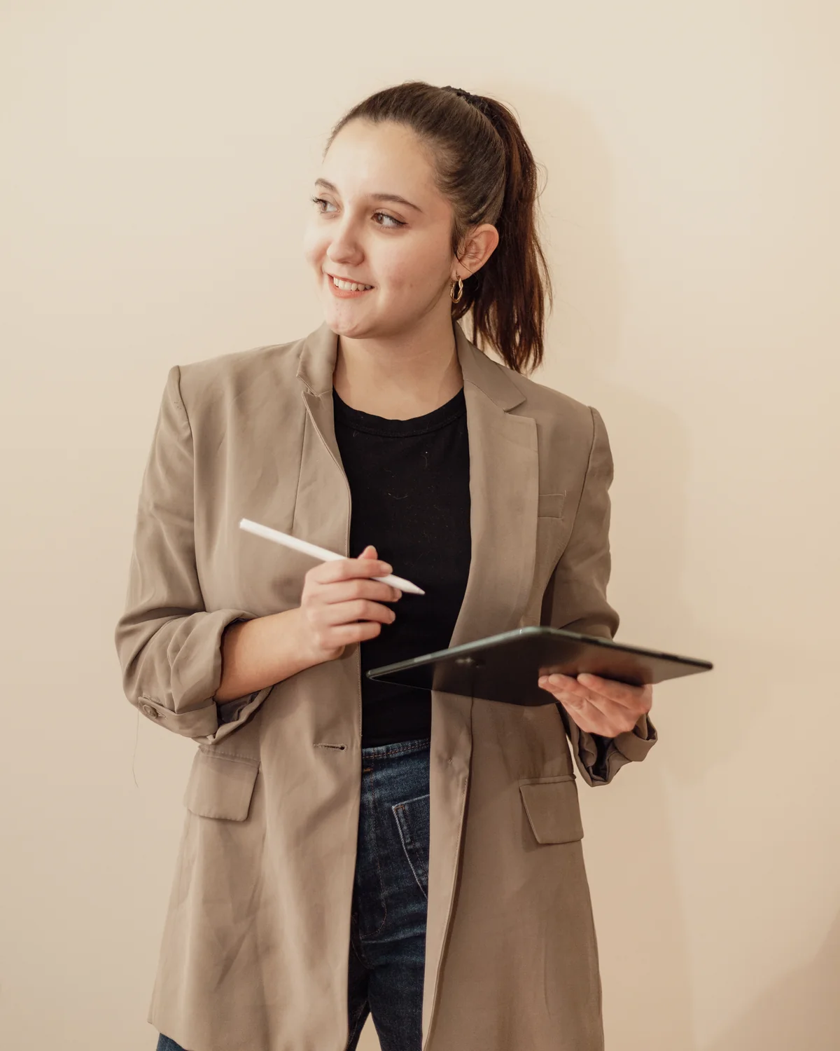 Retrato de Andrea Gómez Torres, diseñadora UX/UI, sonriendo y mirando a un lado con una tableta y un lápiz digital